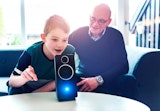 Boy and Grandfather speaking to a digital assistant.